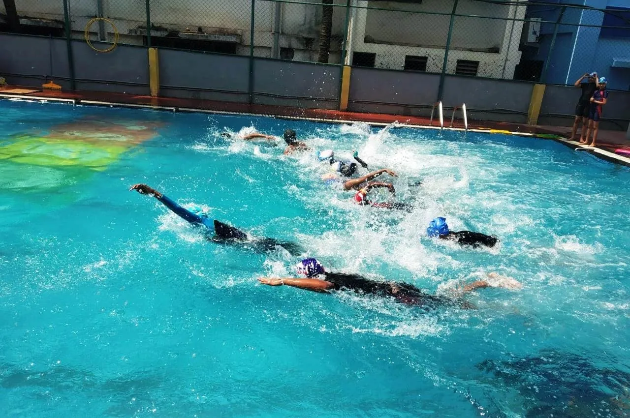 GoldenBee students swimming during a trainer-led session in the school pool
