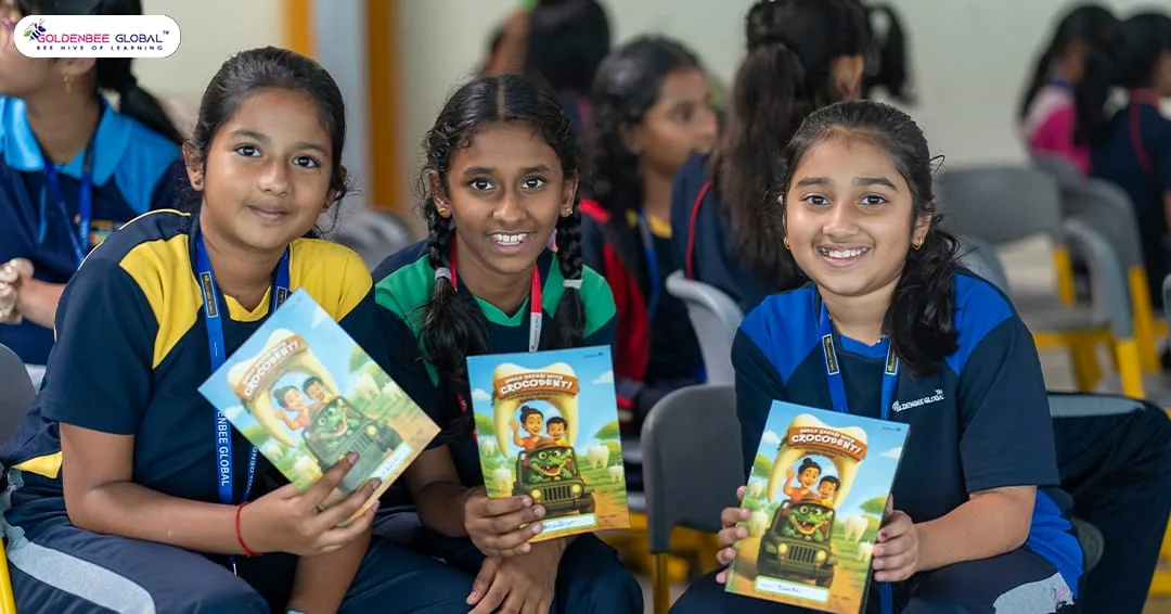 Three GoldenBee students smiling with their dental awareness booklets